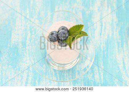 Fresh Blueberries In Yogurt With Mint On Blue Paint Backgrounds In Sun Day
