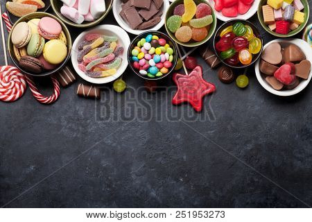 Colorful sweets. Lollipops, macaroons, marshmallow, marmalade and candies. Top view with space for your greetings
