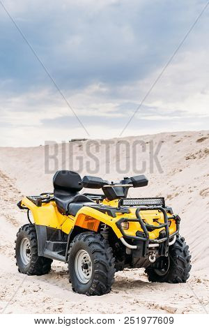 Modern Yellow All-terrain Vehicle Standing In Desert On Cloudy Day