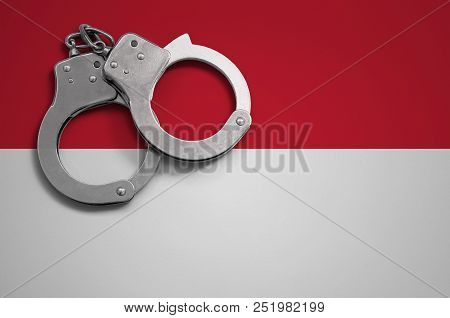 Indonesia Flag  And Police Handcuffs. The Concept Of Crime And Offenses In The Country