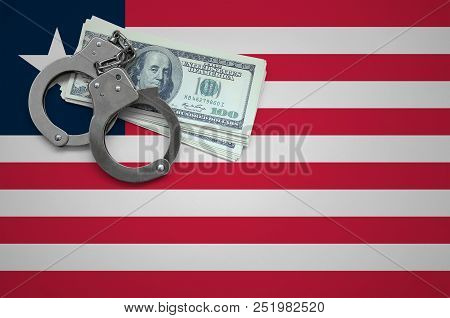 Liberia Flag  With Handcuffs And A Bundle Of Dollars. The Concept Of Breaking The Law And Thieves Cr