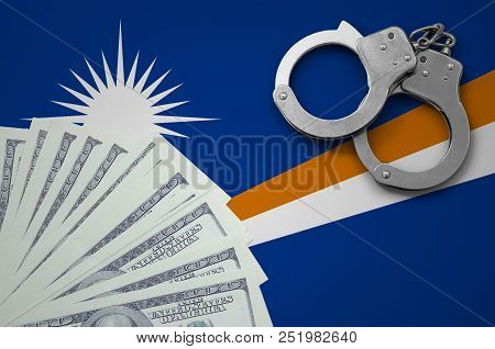 Marshall Islands Flag  With Handcuffs And A Bundle Of Dollars. The Concept Of Illegal Banking Operat