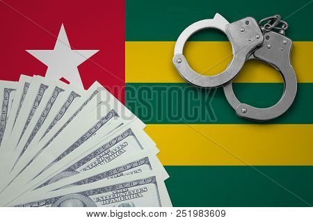 Togo Flag  With Handcuffs And A Bundle Of Dollars. The Concept Of Illegal Banking Operations In Us C