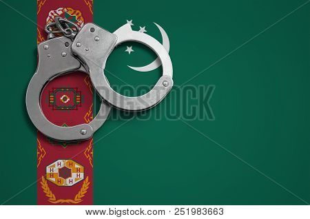 Turkmenistan Flag  And Police Handcuffs. The Concept Of Crime And Offenses In The Country