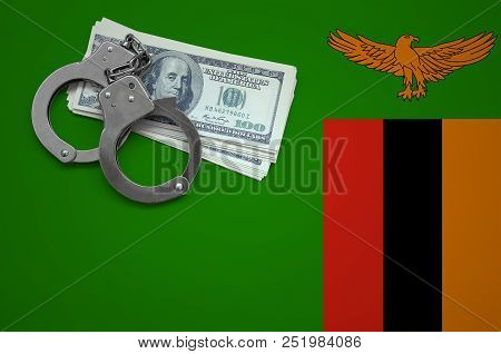 Zambia Flag  With Handcuffs And A Bundle Of Dollars. The Concept Of Breaking The Law And Thieves Cri