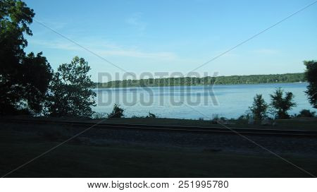 A View Of The Mississippi River With Trees And Train Track In Keokuk, Iowa.