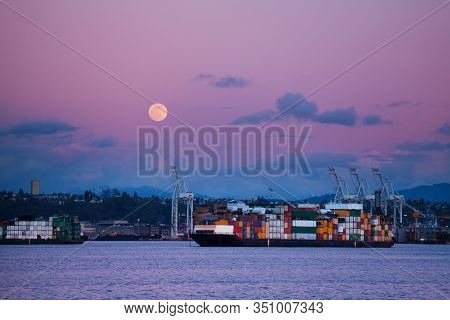 Cargo Ship With Containers In Seattle Port At Night Over Lune In The Sky, Washington, Usa