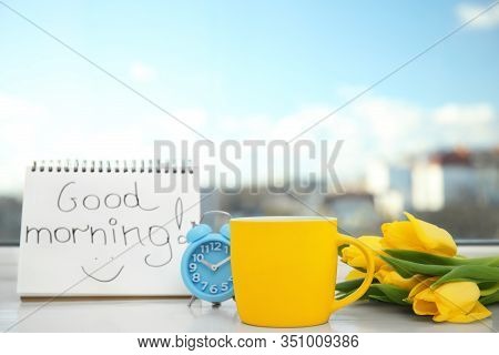 Delicious Coffee, Alarm Clock, Beautiful Flowers And Good Morning Wish On Light Windowsill