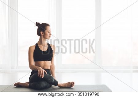 Cow Face Pose. Beautiful Woman Practicing Yoga At Home, Sitting In Gomukasana Position, Looking At C