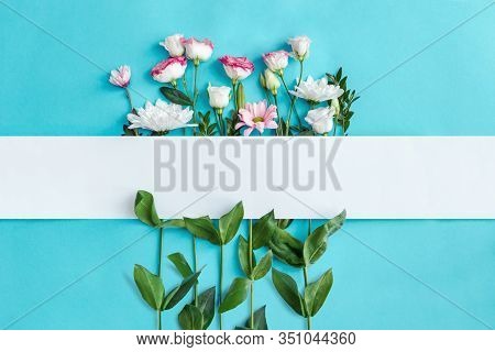 Blank Oblong Sheet Of Paper On Blue Background. Sprigs With Pink And White Flowers, Green Leaves Are