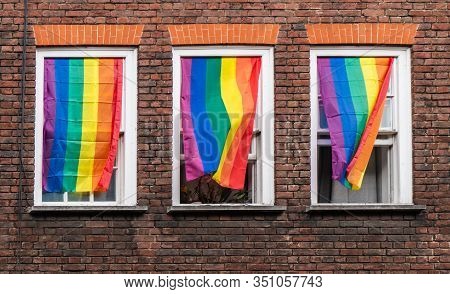 Flying Lgbtq Flags Hanging From Three Windows During London Pride 2019