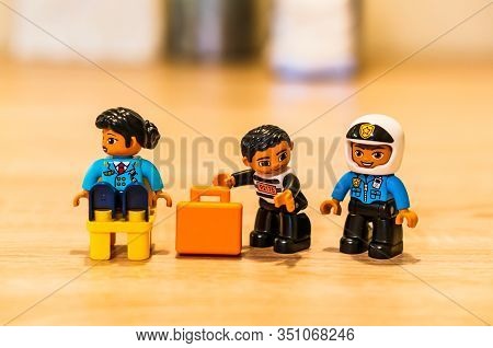Poznan, Poland - February 16, 2020: Lego Duplo Thief Trying To Steal A Orange Suitcase From A Sittin