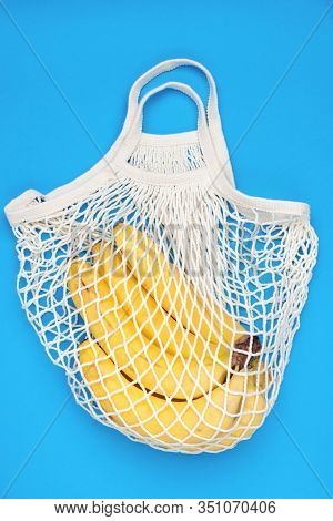 Cotton String Mesh Bag, Reusable Shopping Tote For Grocery With Bananas On A Blue Background. Enviro