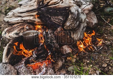 Kettle Stands On Fire. Cooking Food At Fire In Wild. Beautiful Big Log Burns In Bonfire Close-up. Su