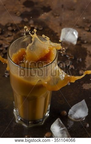 Splash Of Ice Coffee Drink On A Brown Background. Iatte With Ice.