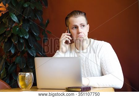 Man, Guy Sitting At Table In Coworking Space, Talking On Mobile Phone With A Client, Feels Angry, Ir