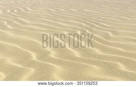 Light Dry Wavey Sand On The Beach With Waves Under Bright Summer Sunlight Close-up Perspective View,