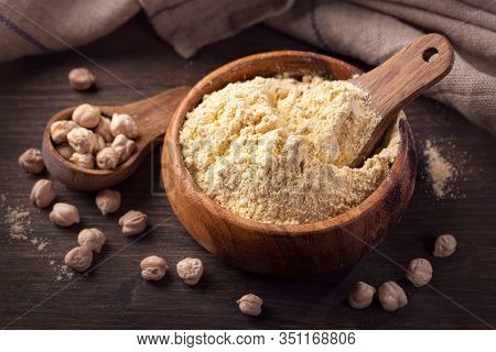 Chickpea flour in a wooden bowl  isolated on a white background