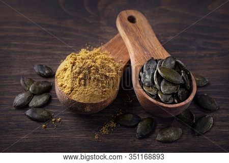 Pumpkin seed flour in a wooden spoon isolated on a white background
