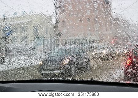View From The Car Windscreen During Rain And Wet Snow. Poor Visibility While Driving Around The City