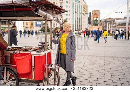 Blonde Girl On A Tray With Roasted Chestnuts On The Street In Istanbul