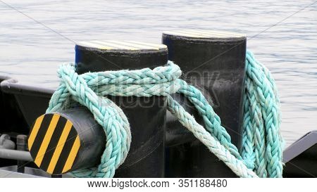 Bollard With Mooring Ropes. Black Large Metal Pier Stands Alone Amid Port Nature