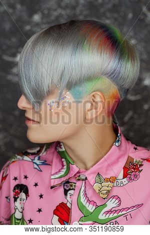 Portrait Of A Young Beautiful Girl In A Pink Shirt On A Gray Background With Dyed Hair. Short Haircu