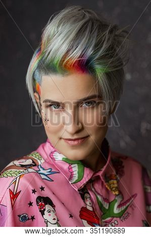 Portrait Of A Young Beautiful Girl In A Pink Shirt On A Gray Background With Dyed Hair. Short Haircu