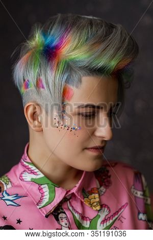 Portrait Of A Young Beautiful Girl In A Pink Shirt On A Gray Background With Dyed Hair. Short Haircu