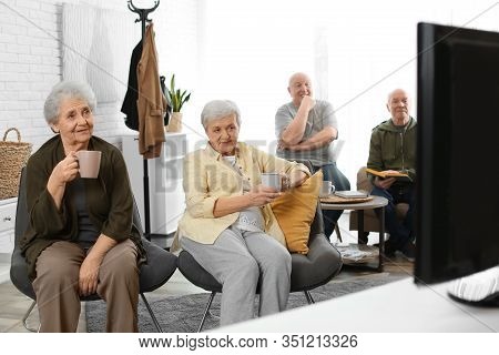 Elderly People Watching Tv In Geriatric Hospice. Senior People Care
