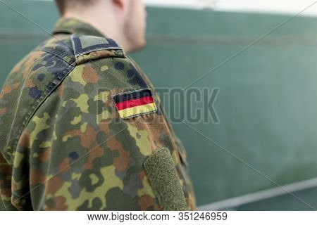 German Soldier Stands In A Classroom . German Word Bundeswehr, Means German Army.