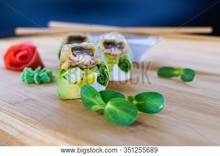 Japanese Sushi Food On A Wooden Board. Salmon, Rice, Wasabi, Ginger, Chopsticks Hashi Japanese Cuisi