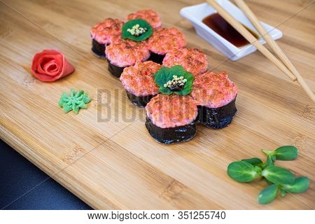 Japanese Sushi Food On A Wooden Board. Salmon, Rice, Wasabi, Ginger, Chopsticks Hashi Japanese Cuisi