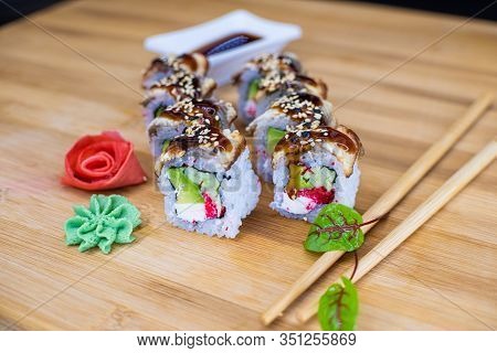 Japanese Sushi Food On A Wooden Board. Salmon, Rice, Wasabi, Ginger, Chopsticks Hashi Japanese Cuisi