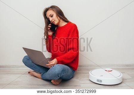 Robot Vacuum Cleaner Cleans Next To A Girl.