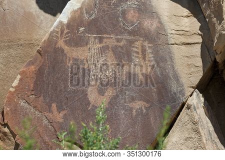 Ancient Petroglyphs Of Animals And A Man Like Figure Are Carved Into Sandstone Rocks Along With Some