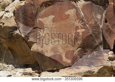 An Ancient Petroglyphs Of A Strange Creature On A Sandstone Rock With More Modern Graffiti From 1834