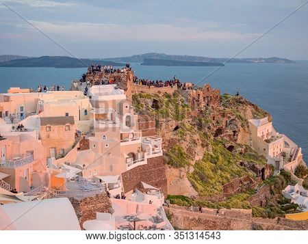 Santorini, Greece- April 12, 2017:
People Watch The Sunset In Santorini Island In Cyclades, Greece