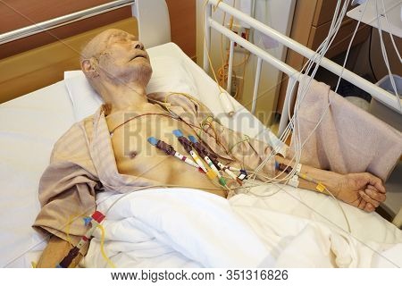 Japanese Old Man Patient Lying On Bed, Take A Cardiogram In Hospital