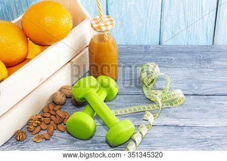 Lots Of Oranges, Dumbbells, Measuring Tape On A Wooden Textured Background. Fitness, Sports Nutritio