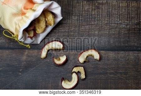 Dried Apple Chips In A Bag On A Brown Wooden Table. Organic Natural Food. Top View. Flat Lay.