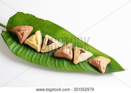 Group Of Variety Triangular Cookies Traditional Meal For Jewish Holiday Purim On Palm Leaf. Leaf Pla