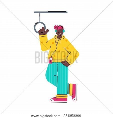Young Man Standing In Subway Train Listening To Music