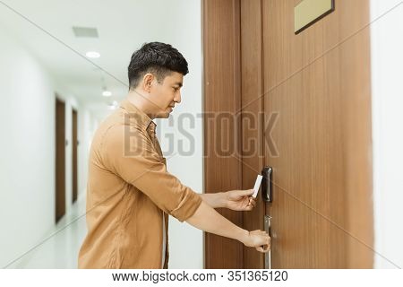 Asian Man Hand Holding Access Card / Key Card Eletronic Door Accessing Control Scanning To Lock And 