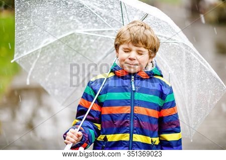 Beautiful Little Kid Boy On Way To School Walking During Sleet, Rain And Snow With An Umbrella On Co