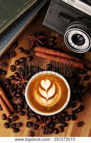 Latte Art Macchiato Ina Black Cup, Coffee With Cinnamon And Roasted Arabica Coffe Beans Decoration