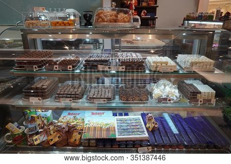 Close Up Of Several Chocolate Sweets In A Shop. Chocolate Candy In A Store Window. Stand With Chocol