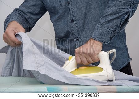 A Man Of About 30 Years Irons His Clothes With An Iron, Leads A Bachelor Lifestyle, Is Going To Visi