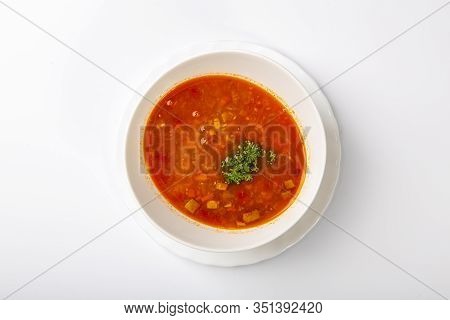 Beef Goulash Soup With Tongue. A White Oval Plate With Red Soup Stands On A White Background. The Vi