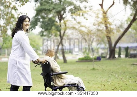 Doctor Help And Care Asian Senior Or Elderly Old Lady Woman Patient Sitting On Wheelchair At Park In